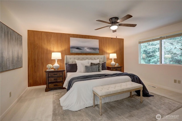 bedroom featuring baseboards, carpet, a ceiling fan, and wood walls