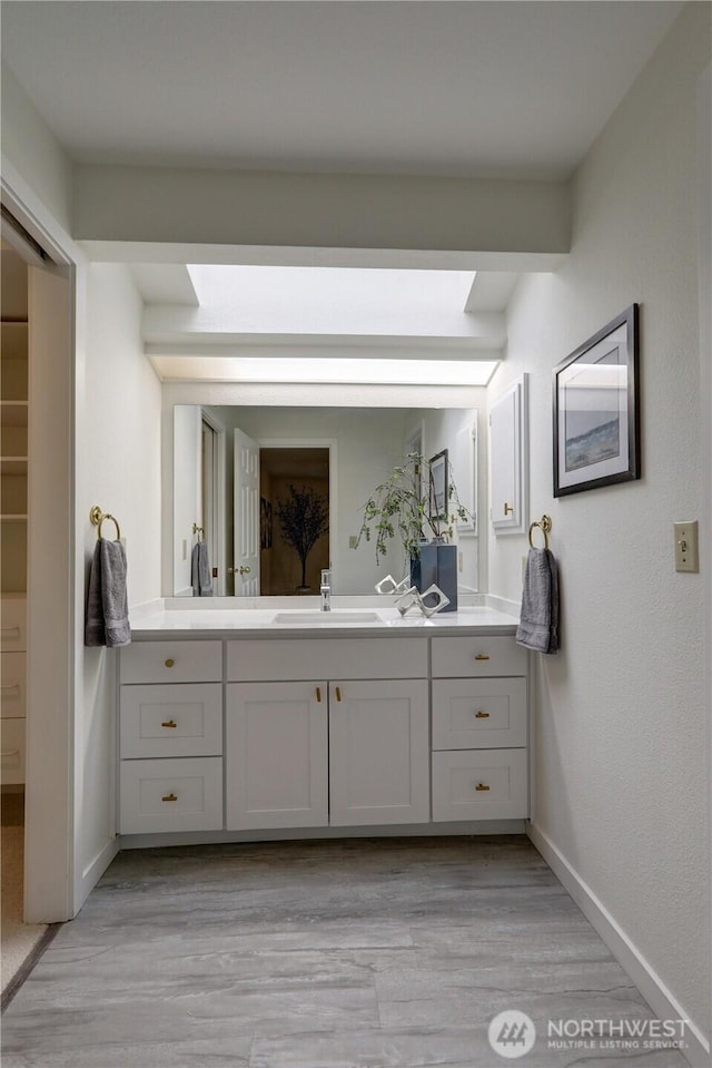 bathroom with vanity, baseboards, and wood finished floors