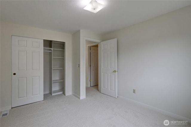 unfurnished bedroom featuring light carpet, baseboards, and a closet