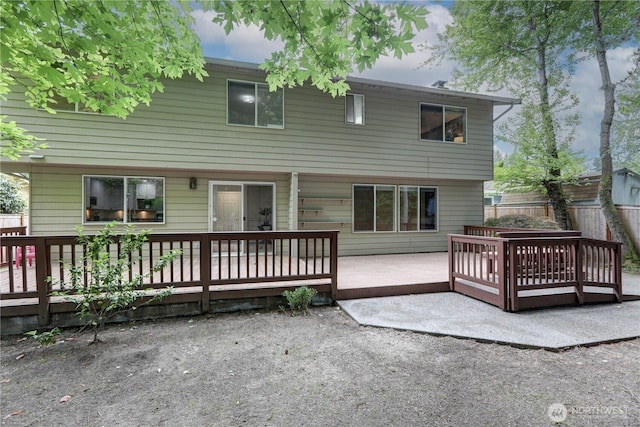 back of property with a wooden deck and fence