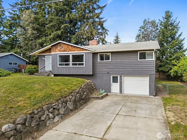 view of front facade with an attached garage, a chimney, and concrete driveway
