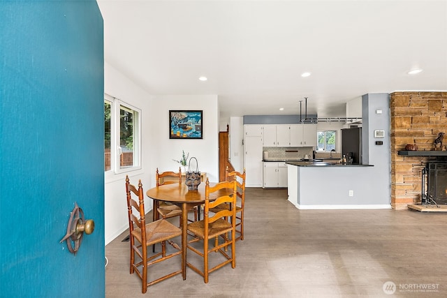 dining space with wood finished floors, recessed lighting, and baseboards