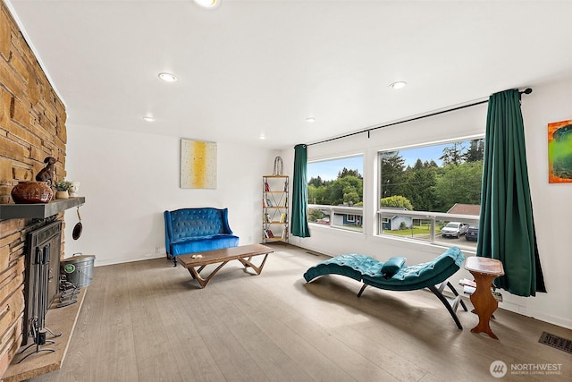 sitting room with recessed lighting, light wood-type flooring, a fireplace, and baseboards