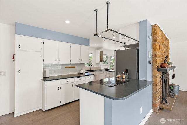 kitchen with freestanding refrigerator, black electric stovetop, a sink, light wood-type flooring, and recessed lighting