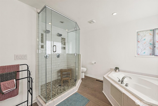 full bathroom with a bath, wood finished floors, a stall shower, and toilet