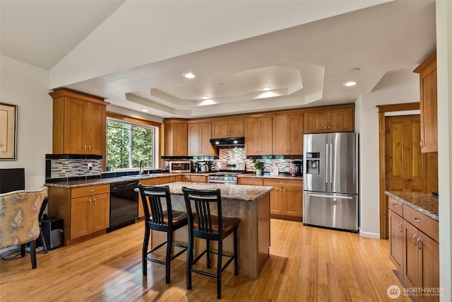 30830 NE 165th St, Duvall, WA 98019 - kitchen with appliances with stainless steel finishes, a tray ceiling, under cabinet range hood, brown cabinets, and recessed lighting