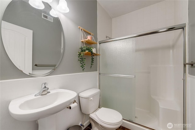 full bath with toilet, an enclosed shower, and a sink