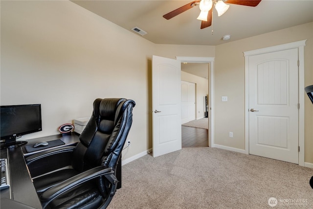 carpeted office with ceiling fan and baseboards