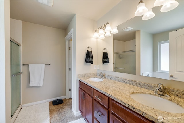full bathroom featuring a stall shower, baseboards, double vanity, and a chandelier