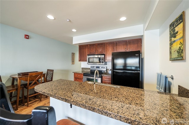 322 W W Woodin Ave Unit 523, Chelan, WA 98816 - kitchen with stainless steel appliances, light wood-type flooring, recessed lighting, a sink, and a kitchen bar