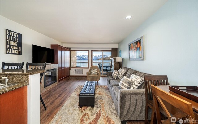 322 W W Woodin Ave Unit 523, Chelan, WA 98816 - living room with a glass covered fireplace, dark wood-style flooring, and a wall mounted air conditioner