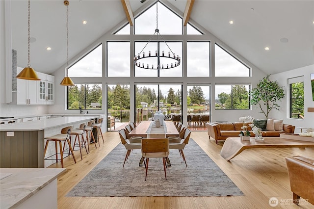 29108 218th Pl SE, Black Diamond, WA 98010 - dining space featuring high vaulted ceiling, a chandelier, light wood-style floors, and beamed ceiling