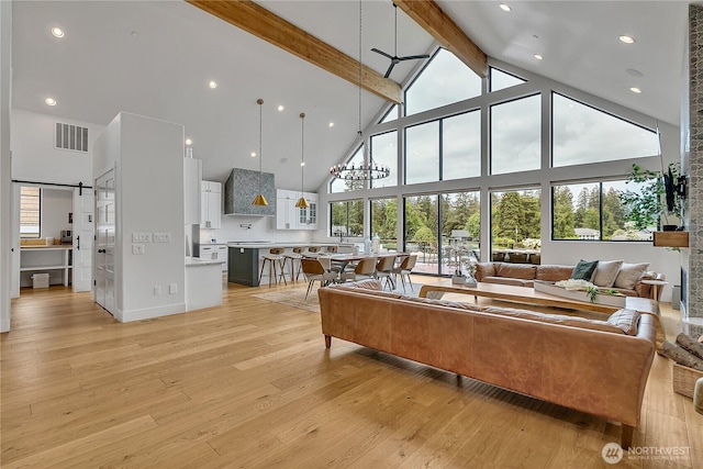 29108 218th Pl SE, Black Diamond, WA 98010 - living room with high vaulted ceiling, beamed ceiling, light wood-style floors, and a barn door