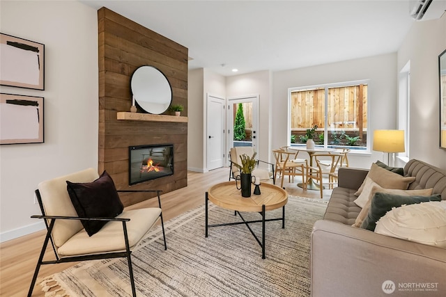 1740A NW 62nd St, Seattle, WA 98107 - living room featuring a wall mounted air conditioner, light wood-style floors, a large fireplace, baseboards, and recessed lighting