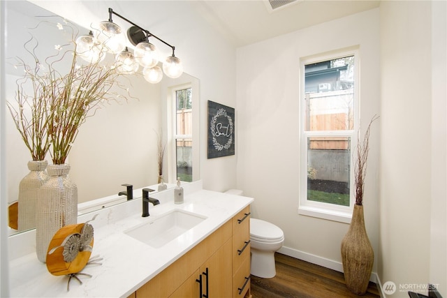 18809 94th Ave W, Edmonds, WA 98020 - bathroom with wood finished floors, toilet, vanity, baseboards, and a chandelier
