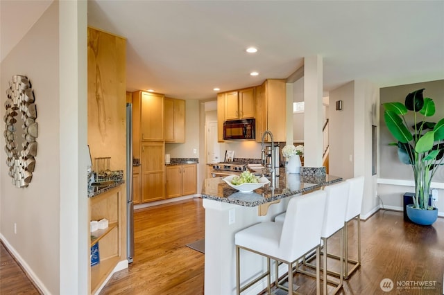 12045 Lakeside Pl NE, Seattle, WA 98125 - kitchen featuring black microwave, light wood-style flooring, dark stone counters, a peninsula, and recessed lighting