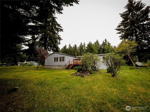 15712 123rd Ave SE, Yelm, WA 98597 - view of grassy yard with a wooden deck and view of wooded area