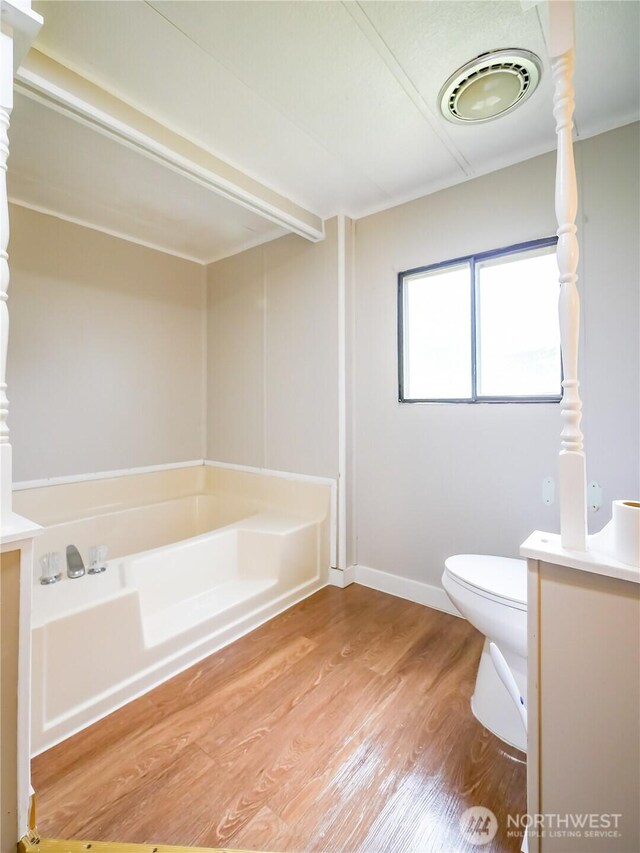 15712 123rd Ave SE, Yelm, WA 98597 - bathroom featuring a bath, wood finished floors, toilet, and vanity