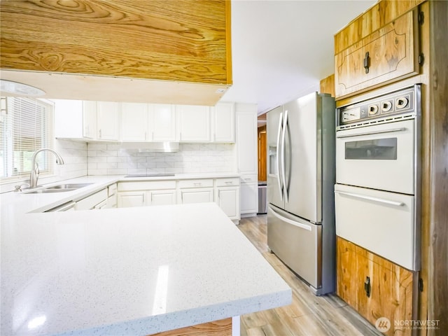 15712 123rd Ave SE, Yelm, WA 98597 - kitchen with stainless steel refrigerator with ice dispenser, a sink, black electric cooktop, double oven, and backsplash