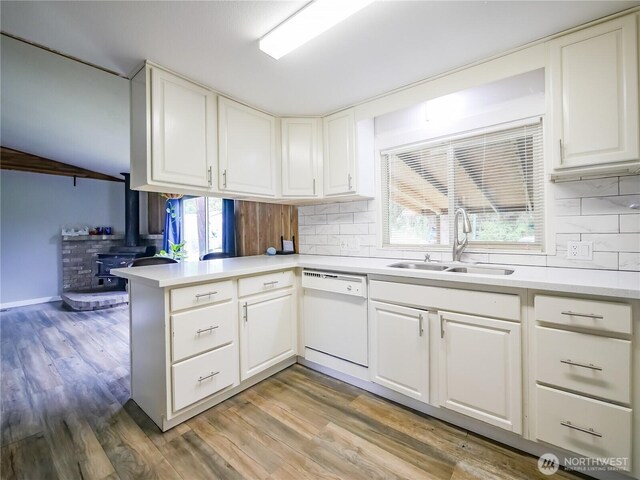15712 123rd Ave SE, Yelm, WA 98597 - kitchen featuring a sink, white dishwasher, a wood stove, and tasteful backsplash