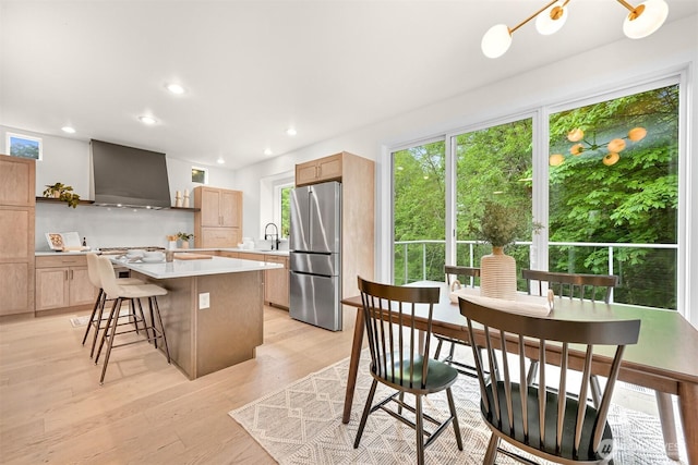 4964 Lewis Ave, Bellingham, WA 98229 - kitchen featuring freestanding refrigerator, wall chimney exhaust hood, a sink, light countertops, and a center island