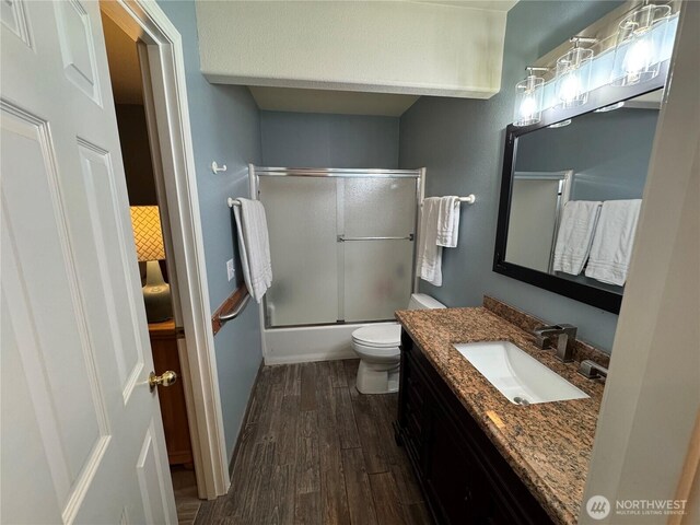 2615 Sea Crest Ave N, Long Beach, WA 98631 - full bath featuring wood finished floors, toilet, vanity, and bath / shower combo with glass door