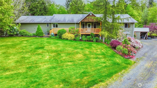 view of front facade with driveway, a front yard, a carport, and a wooden deck