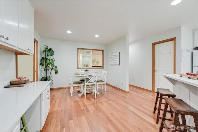 dining room with recessed lighting, light wood finished floors, and baseboards