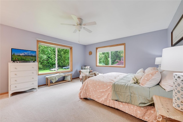 carpeted bedroom featuring multiple windows, baseboards, and ceiling fan