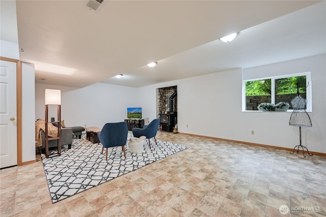 dining room with stone finish floors, baseboards, and a wood stove