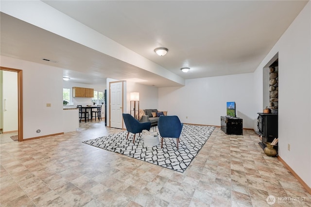 dining space featuring stone finish flooring, baseboards, and a wood stove