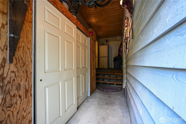 corridor featuring unfinished concrete floors and wood ceiling