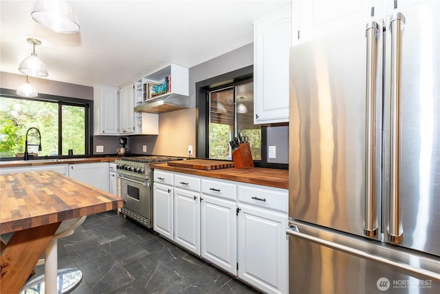 42520 State Route 2, Gold Bar, WA 98251 - kitchen with stainless steel appliances, butcher block counters, a sink, white cabinetry, and decorative light fixtures