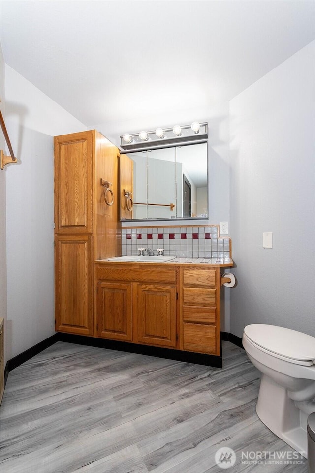 42520 State Route 2, Gold Bar, WA 98251 - bathroom featuring toilet, tasteful backsplash, vanity, wood finished floors, and baseboards