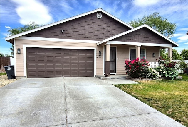 500 E Linden Ave, Moses Lake, WA 98837 - view of front facade with covered porch, concrete driveway, an attached garage, and a front yard