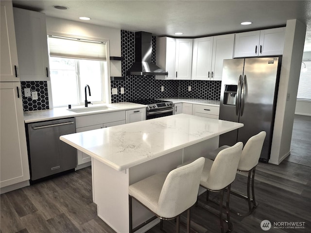 500 E Linden Ave, Moses Lake, WA 98837 - kitchen featuring appliances with stainless steel finishes, wall chimney exhaust hood, a sink, white cabinetry, and dark wood-type flooring