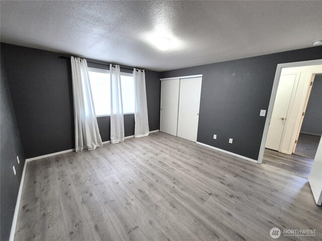 500 E Linden Ave, Moses Lake, WA 98837 - unfurnished bedroom with a textured ceiling, wood finished floors, baseboards, and a closet