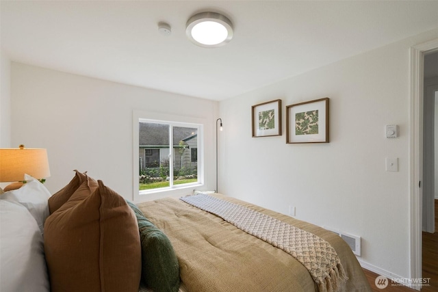 bedroom featuring wood finished floors and baseboards