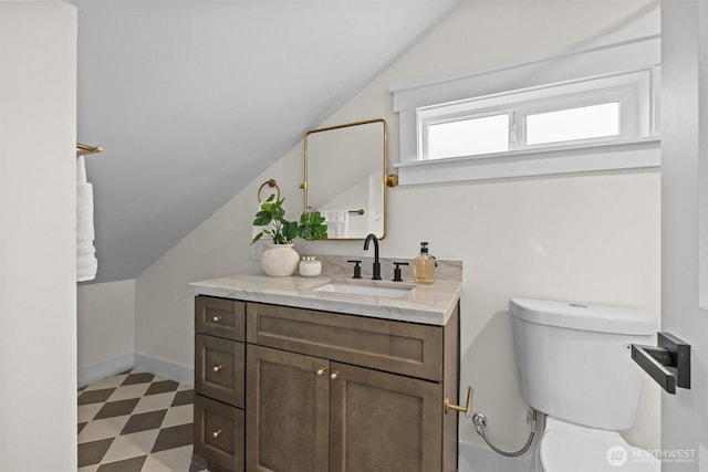 2711 10th Ave W, Seattle, WA 98119 - bathroom featuring lofted ceiling, vanity, toilet, tile patterned floors, and baseboards