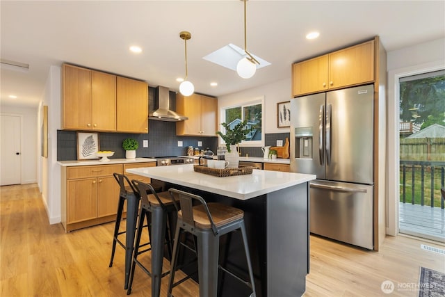 1831 201st Pl SW, Lynnwood, WA 98036 - kitchen with stainless steel appliances, wall chimney range hood, decorative backsplash, light countertops, and light wood finished floors
