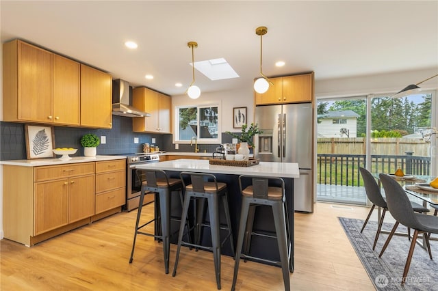 1831 201st Pl SW, Lynnwood, WA 98036 - kitchen featuring wall chimney range hood, stainless steel appliances, light wood-style flooring, a skylight, and recessed lighting
