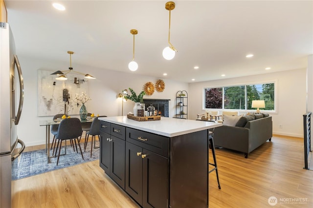 1831 201st Pl SW, Lynnwood, WA 98036 - kitchen with stainless steel refrigerator, light wood-style floors, a kitchen island, light countertops, and recessed lighting