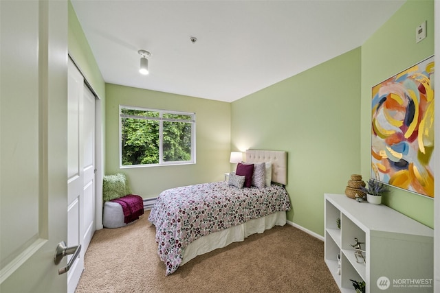 carpeted bedroom with a closet, baseboards, and a baseboard heating unit