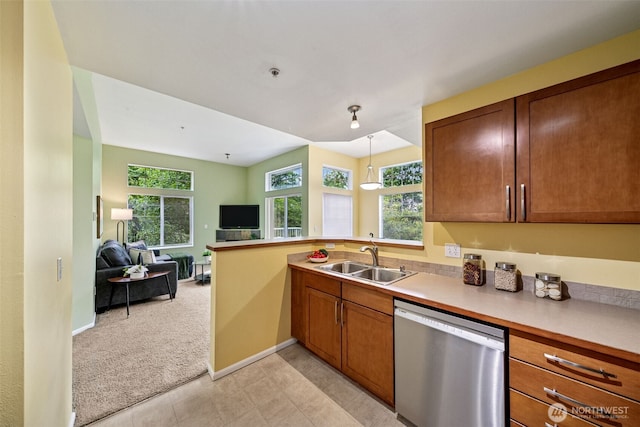 kitchen featuring dishwasher, a sink, open floor plan, light carpet, and a peninsula