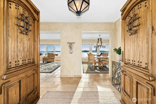 24635 8th Ave S, Des Moines, WA 98198 - foyer featuring stone tile flooring, a chandelier, and a water view