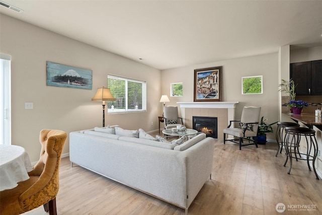 4914 Bering St, Gig Harbor, WA 98332 - living area featuring a tile fireplace, light wood-type flooring, and baseboards