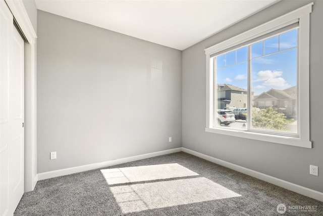 unfurnished room with carpet floors and baseboards
