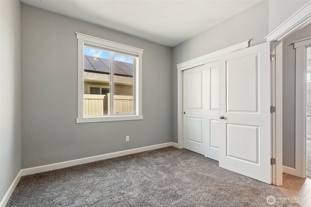 unfurnished bedroom with carpet, baseboards, and a closet
