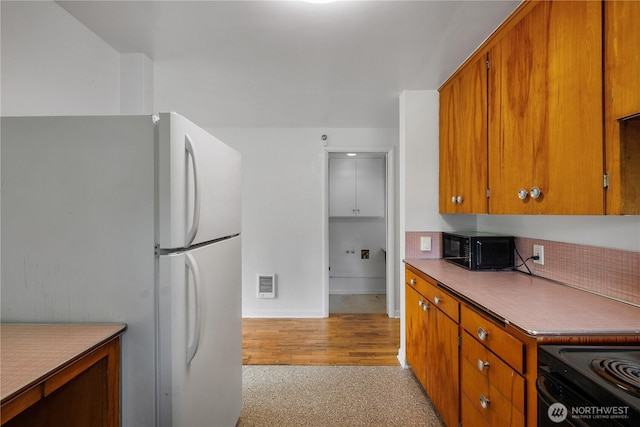 2116 Union Ave SE, Olympia, WA 98501 - kitchen featuring black appliances, brown cabinetry, baseboards, and light wood-type flooring