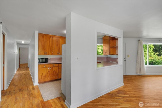 2116 Union Ave SE, Olympia, WA 98501 - kitchen with black microwave, brown cabinets, light wood-style flooring, baseboards, and light countertops